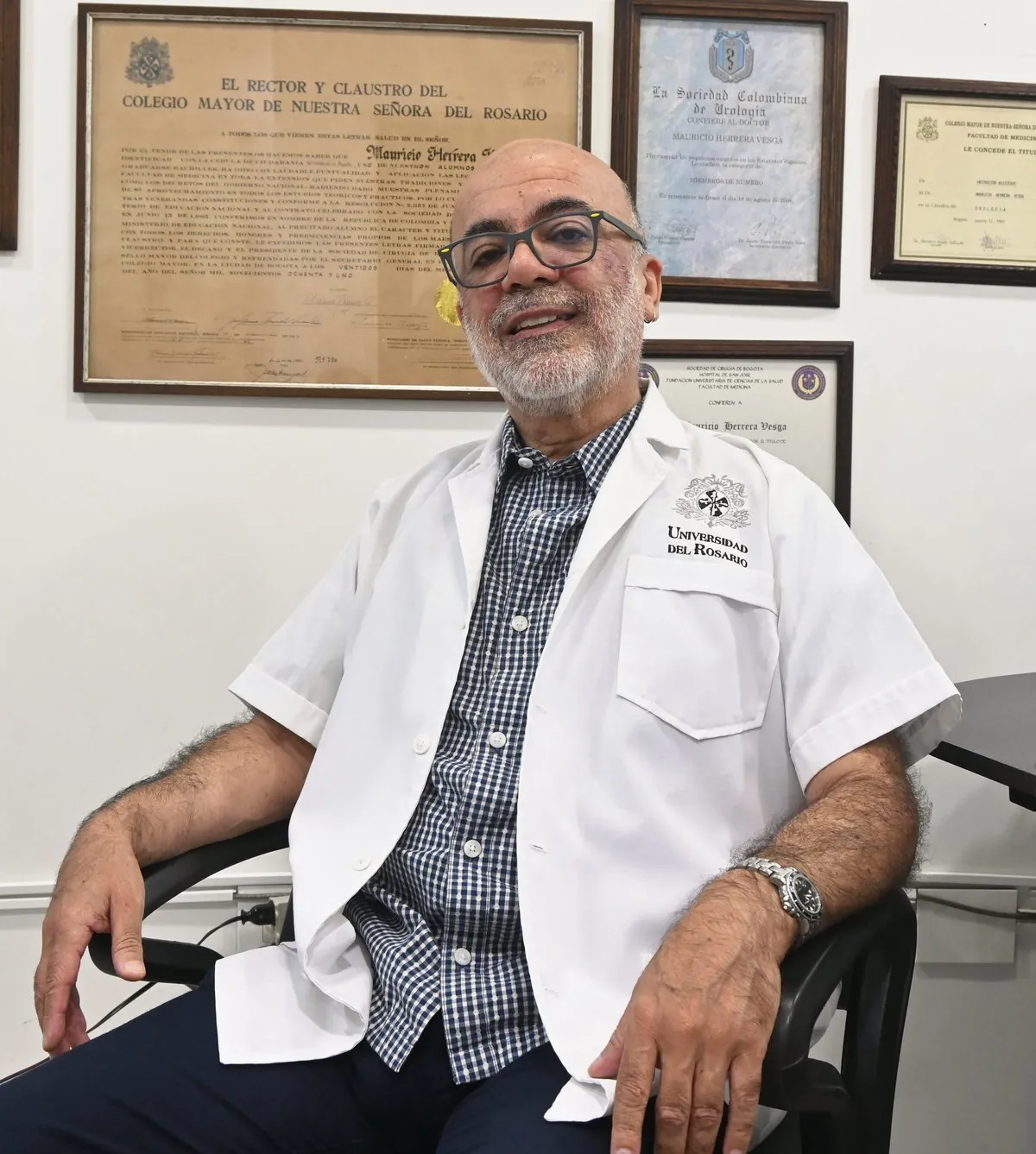 El Dr. Mauricio Herrera en su consultorio, frente a sus diplomas de la Universidad del Rosario