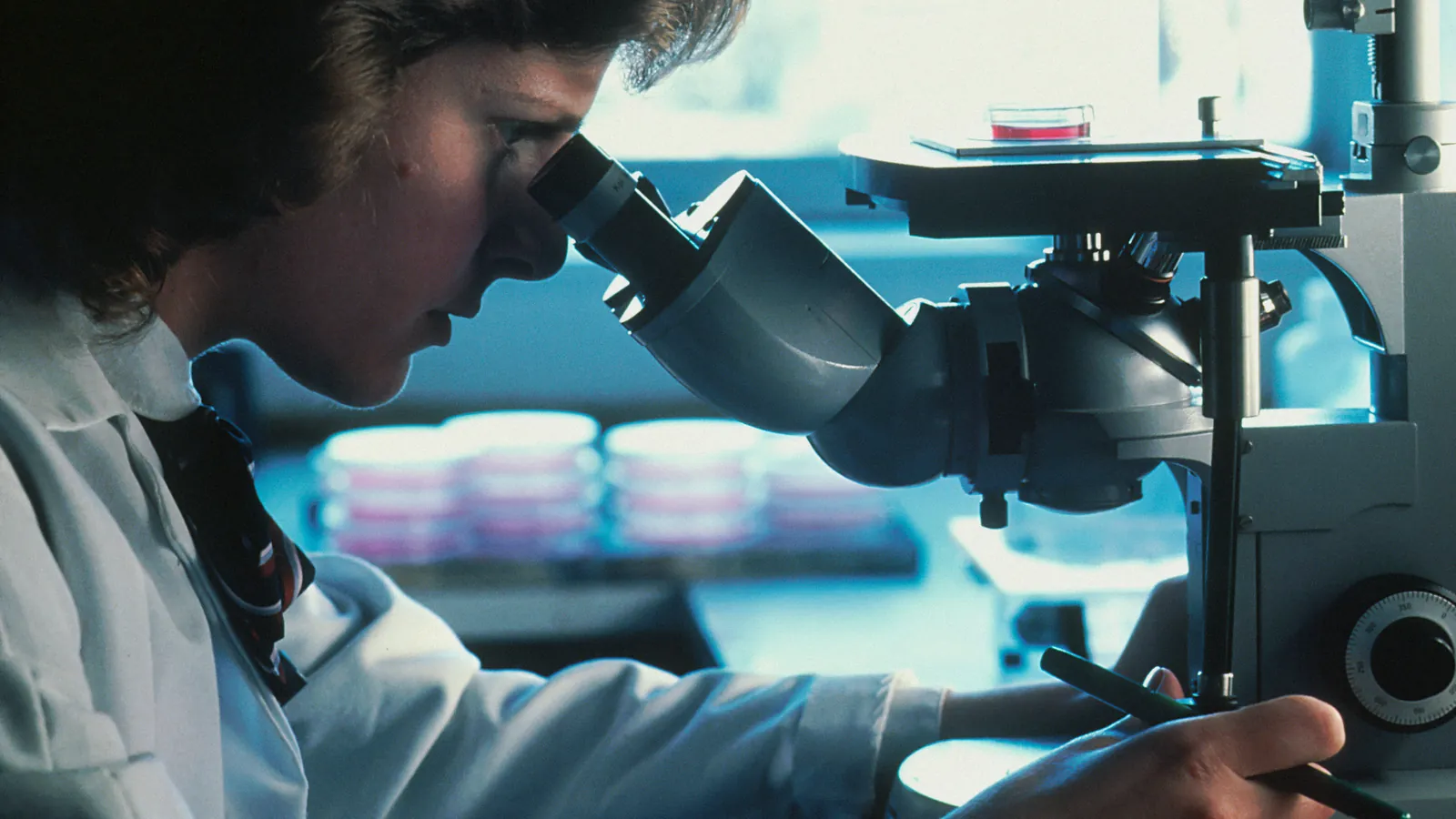 Patóloga analizando al microscopio la muestra de una biopsia de próstata